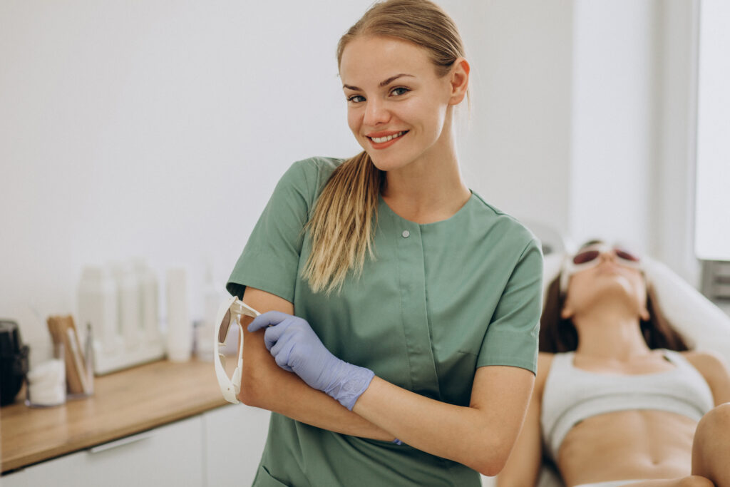 Uśmiechnięta lekarka medycyny estetycznej w zielonym kitlu.